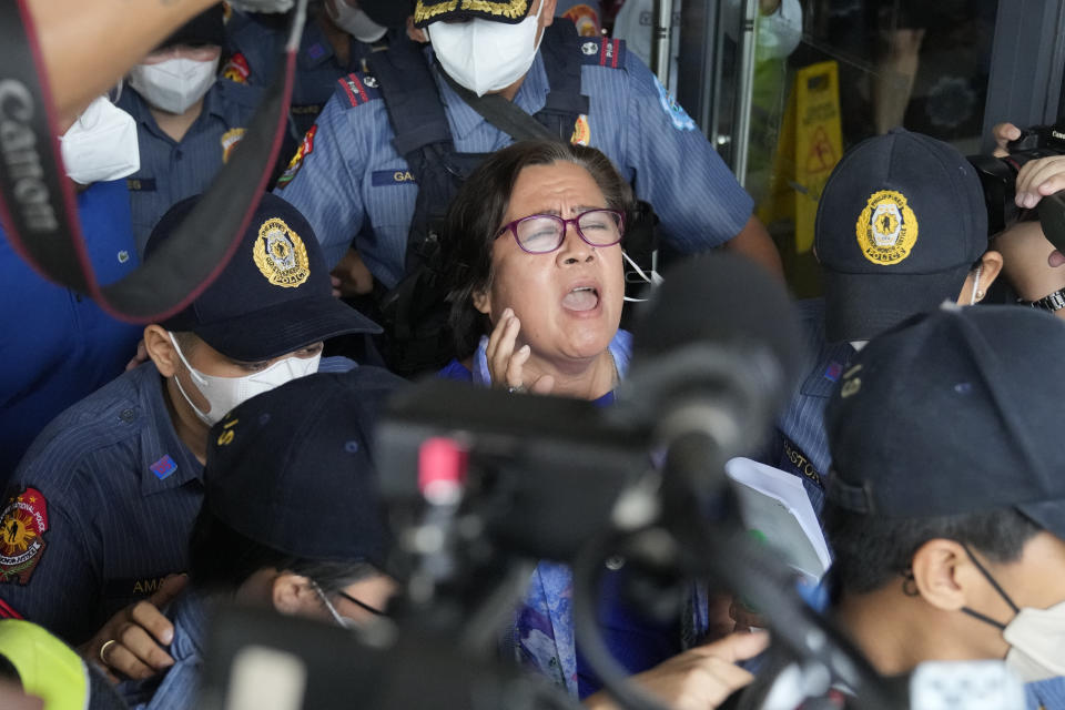 Detained former opposition Senator Leila de Lima, center, reacts as she goes out of the Muntinlupa trial court on Friday, May 12, 2023 in Muntinlupa, Philippines. De Lima was acquitted by the Muntinlupa court in one of her drug related charges she says were fabricated by former President Rodrigo Duterte and his officials in an attempt to muzzle her criticism of his deadly crackdown on illegal drugs. (AP Photo/Aaron Favila)