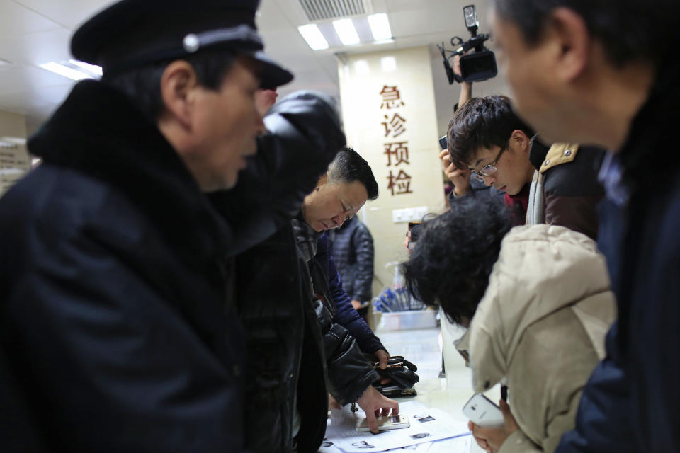 People try to identify their relatives at a hospital, from pictures of some of the victims of a stampede during a New Year's celebration on the Bund, central Shanghai