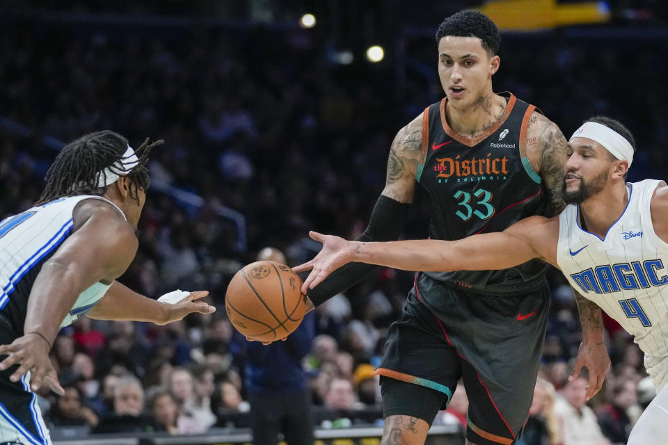 Orlando Magic guard Jalen Suggs (4) tips the ball away from Washington Wizards forward Kyle Kuzma (33) during the first half of an NBA basketball game Tuesday, Dec. 26, 2023, in Washington. (AP Photo/Alex Brandon)