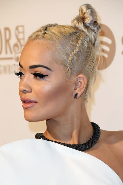 Chongo con trenzas cocidas. Si quieres darle ‘una vuelta de tuerca’ a este clásico peinado, puedes inspirarte en la cantante Rita Ora y sumarle trenzas cocidas a tu look. - Foto: Frederick M. Brown/Getty Images