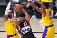 Denver Nuggets' Jamal Murray (27) is defended by Los Angeles Lakers' Kentavious Caldwell-Pope (1) and Rajon Rondo (9) during the second half of an NBA conference final playoff basketball game Thursday, Sept. 24, 2020, in Lake Buena Vista, Fla. (AP Photo/Mark J. Terrill)