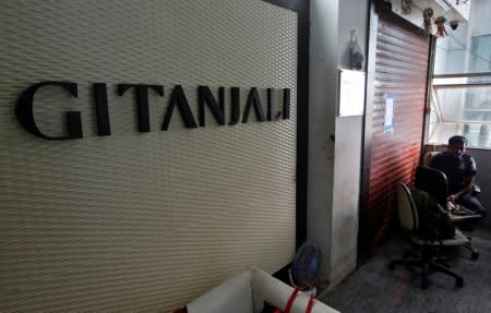 A security guard sits beside a sealed office of Gitanjali jewellers in Mumbai, India, July 23, 2018. REUTERS/Francis Mascarenhas