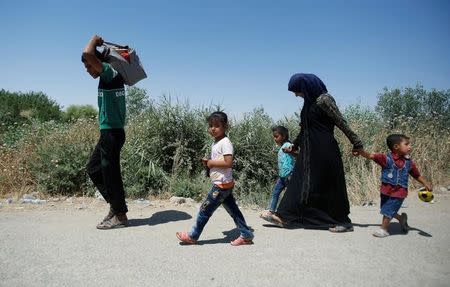 Iraqis walk as they are about to cross the floating bridge between east and west of Mosul, Iraq, July 21, 2017. REUTERS/Khalid Al-Mousily