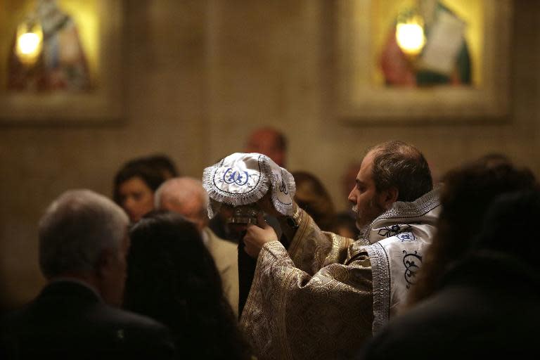 A Syrian Christan priest performs a mass at the Greek Orthodox church in the government controlled area of Aleppo on November 16, 2014