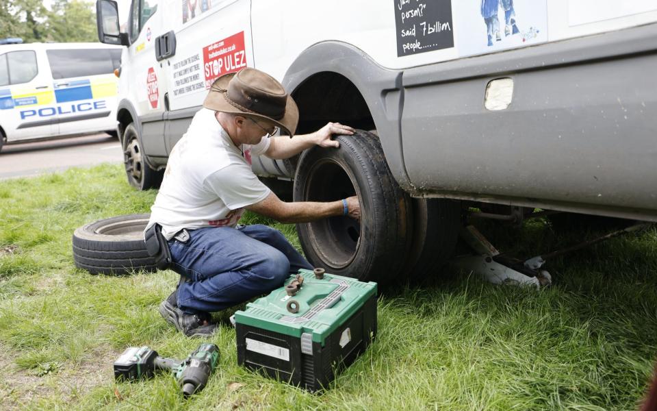 Ein Anti-Ulez-Demonstrant inspiziert seinen beschädigten Reifen in Bromley