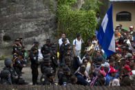 Guatemalan police agents block the border crossing where hundreds of Honduran migrants have arrived, in Agua Caliente, Guatemala, Monday, Oct. 15, 2018. The caravan of Honduran migrants moved towards the country's border with Guatemala in a desperate attempt to flee poverty and seek new lives in the United States. (AP Photo/Moises Castillo)