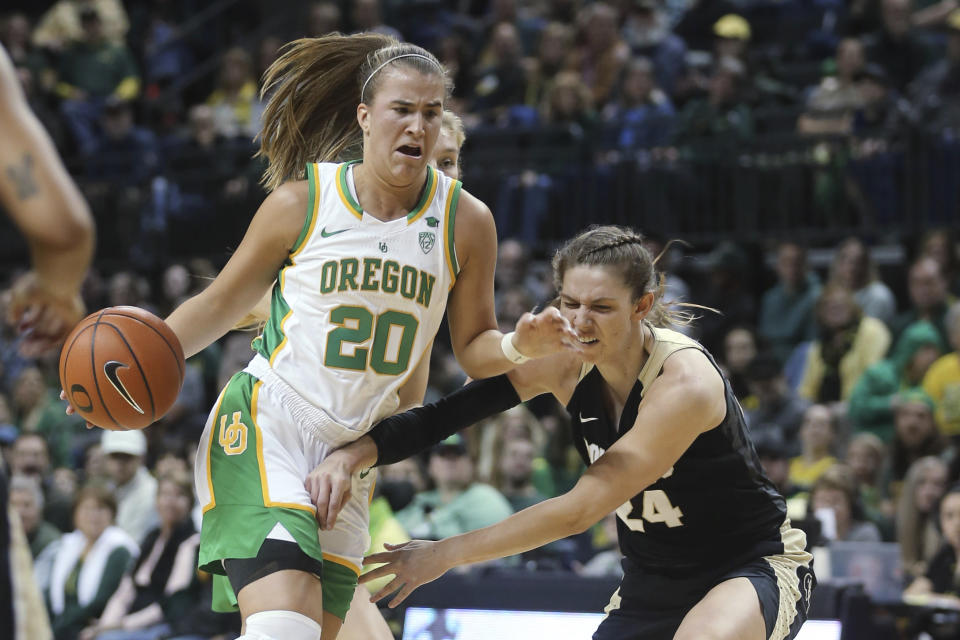 Oregon's Sabrina Ionescu, left, drives to the basket as Colorado's Aubrey Knight defends during the second quarter of an NCAA college basketball game in Eugene, Ore., Friday, Jan. 3, 2020. (AP Photo/Chris Pietsch)