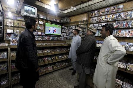 Men watch the Pakistan Super League (PSL) cricket match between Islamabad United and Peshawar Zalmi on TV sets at a CD shop in Rawalpindi, Pakistan, February 21, 2016. REUTERS/Faisal Mahmood