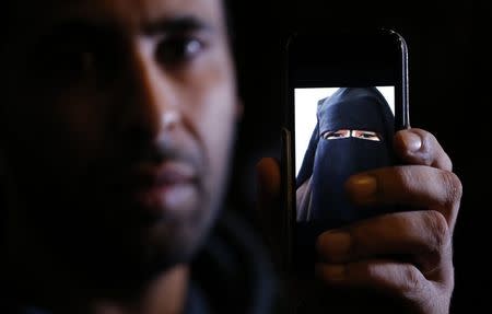 Foad, the brother of 15 year-old Nora who left her home in Avignon for Syria nine months ago, shows a portrait he took last September on his cell phone as he attends an interview with Reuters in Paris, October 6, 2014. REUTERS/Christian Hartmann