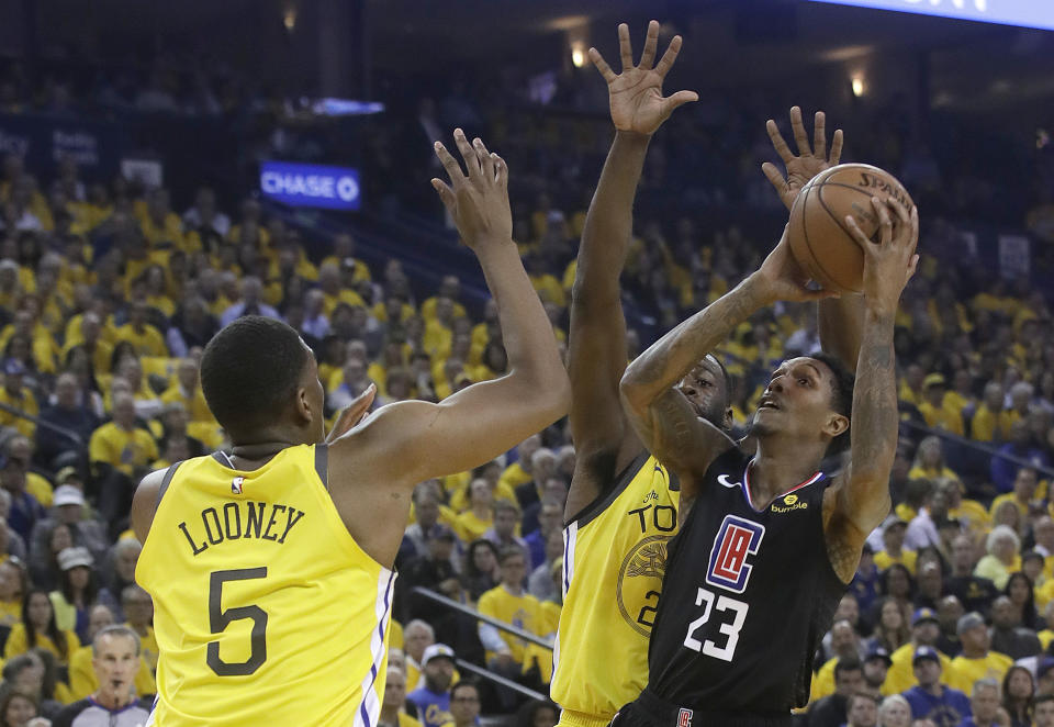 Los Angeles Clippers guard Lou Williams (23) shoots against Golden State Warriors center Kevon Looney (5) and forward Draymond Green during the first half of Game 2 of a first-round NBA basketball playoff series in Oakland, Calif., Monday, April 15, 2019. (AP Photo/Jeff Chiu)