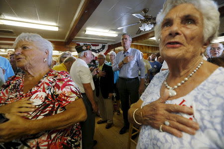 U.S. Republican presidential candidate Jeb Bush (C) joins the audience in reciting the U.S. Pledge of Allegiance at a campaign town hall meeting in Laconia, New Hampshire September 3, 2015. REUTERS/Brian Snyder