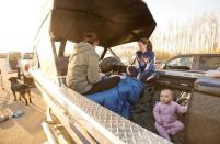 A family takes refuge in the back of their boat after evacuation at a rest stop near Fort McMurray, Alta., on Wednesday, May 4, 2016. THE CANADIAN PRESS/Jason Franson