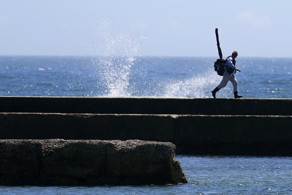 An angler prepares to fish at Numanouchi port, Iwaki, northeastern Japan, near the Fukushima Daiichi nuclear power plant, damaged by a massive March 11, 2011, earthquake and tsunami, on Friday, Aug. 25, 2023. Fish auction prices at a port south of the Fukushima Daiichi nuclear power plant Friday somehow dipped amid uncertainty about how consumers may respond a day after release to sea of treated and diluted radioactive wastewater began despite protests at home and in neighboring countries. (AP Photo/Eugene Hoshiko)