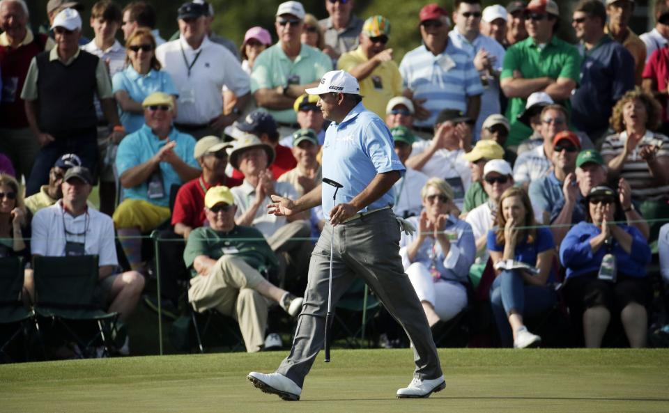 Angel Cabrera, of Argentina, waves to spectators as he walks up the 18th fairway during the second round of the Masters golf tournament Friday, April 11, 2014, in Augusta, Ga. (AP Photo/Charlie Riedel)