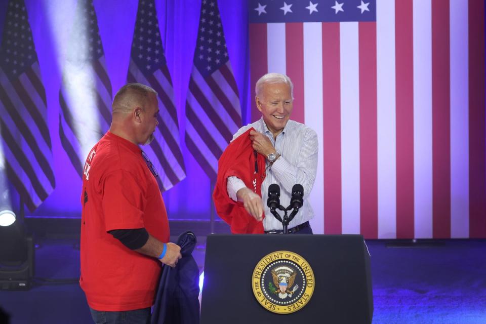 President Joe Biden puts on a United Auto Workers shirt before speaking to autoworkers at the Community Complex Building  in Belvidere, Illinois in November (Getty Images)