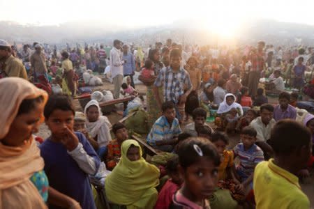 FILE PHOTO: The sun rises as thousands of Rohingya refugees who fled from Myanmar a day before wait by the road where they spent the night between refugee camps, near Cox's Bazar, Bangladesh October 10, 2017. To match Special Report MYANMAR-FACEBOOK/HATE   REUTERS/Damir Sagolj/File Photo