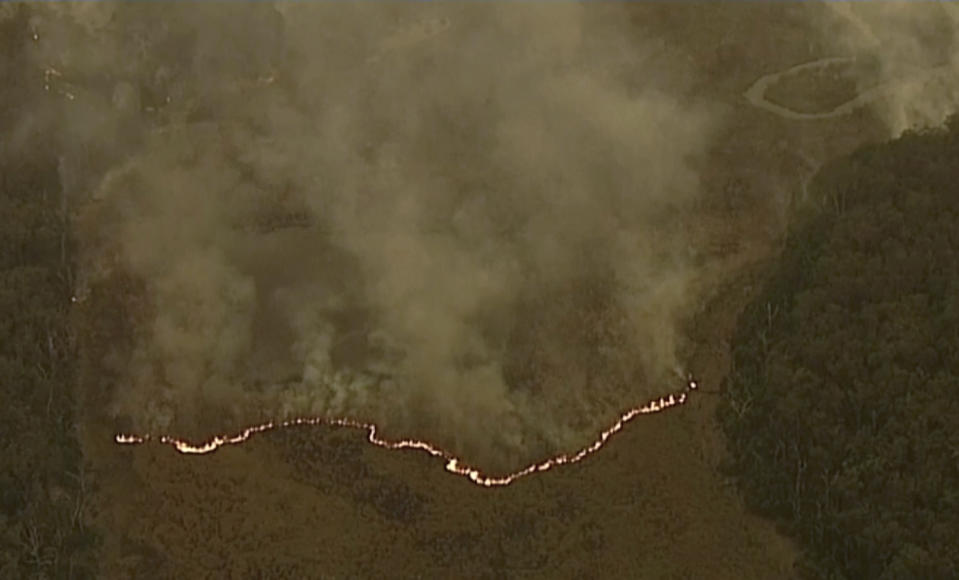 In this image made from video, an aerial view shows wildfires in the forests of Gippsland, Victoria, Australia, Dec. 31, 2019. Wildfires burning across Australia's two most-populous states have trapped residents of a seaside town in apocalyptic conditions, destroyed many properties and caused at least two fatalities. (Australian Broadcasting Corporation, Channel 7, Channel 9 via AP)