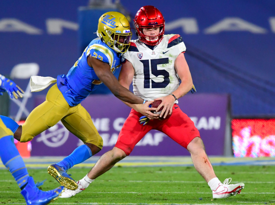 UCLA defensive back Obi Eboh strips the ball from Arizona quarterback Will Plummer