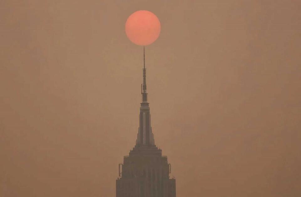 PHOTO: Smoke from wildfires in Canada shrouds the Empire State Building as the sun rises in New York City, June 6, 2023.  (Gary Hershorn/ABC News)