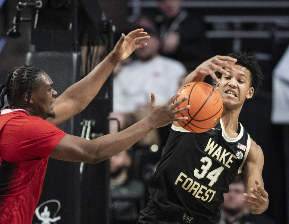 Wake Forest forward Bobi Klintman (34) and North Carolina State forward D.J. Burns, Jr. (30) reach for a rebound in the first half of an NCAA college basketball game on Saturday, Jan. 28, 2023, at Joel Coliseum in Winston-Salem, N.C. (Allison Lee Isley/The Winston-Salem Journal via AP)