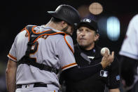 San Francisco Giants catcher Curt Casali, left, argues with umpire Chris Guccione after the umpire called Giants pitcher Johnny Cueto for a balk during the second inning of the team's baseball game against the Arizona Diamondbacks, Tuesday, Aug. 3, 2021, in Phoenix. (AP Photo/Ross D. Franklin)