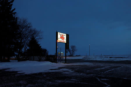 A lit sign for the Maple Leaf Motel is seen at dusk in Emerson, Manitoba, Canada February 25, 2017. REUTERS/Lyle Stafford