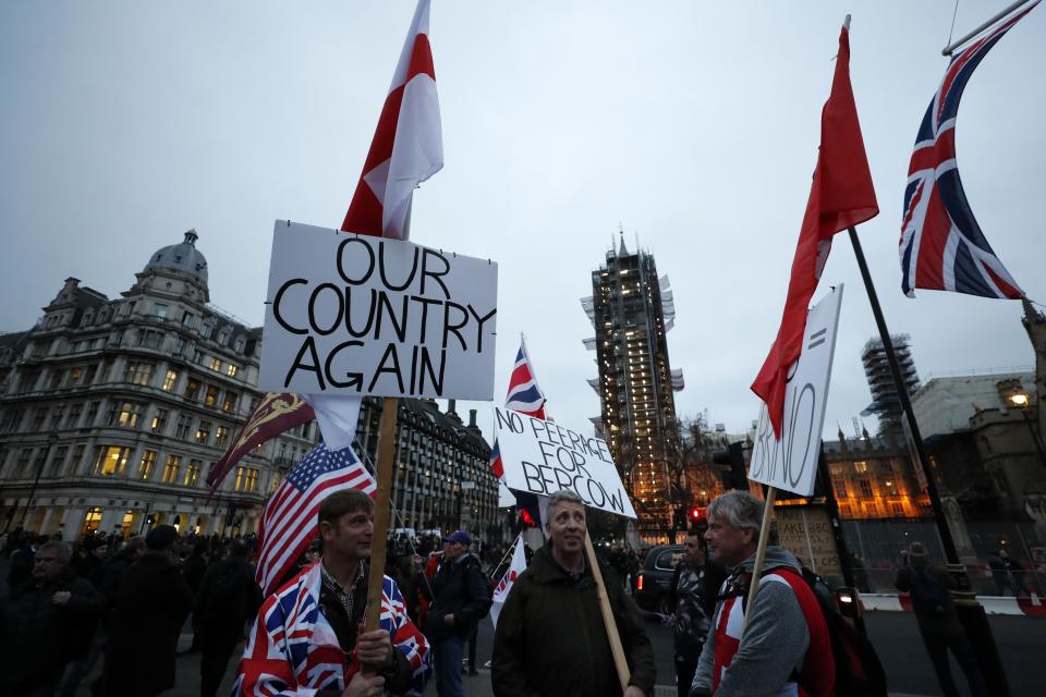 Revellers hold signs and Union Jacks on Parliament Square