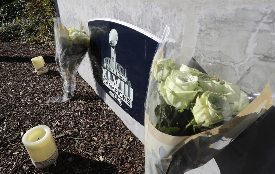 Flowers and candles rest near a sign for the Seattle Seahawks NFL football team headquarters Tuesday, Oct. 16, 2018, in Renton, Wash. in tribute to team owner Paul Allen, who died Monday, Oct. 15, 2018 in Seattle. (AP Photo/Ted S. Warren)