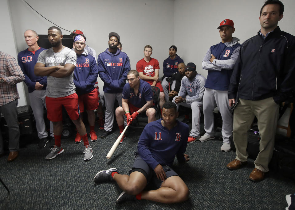 Boston Red Sox manager Alex Cora, second from right, listens with players and team officials at a news conference for shortstop Xander Bogaerts before a baseball game against the Oakland Athletics in Oakland, Calif., Monday, April 1, 2019. (AP Photo/Jeff Chiu)