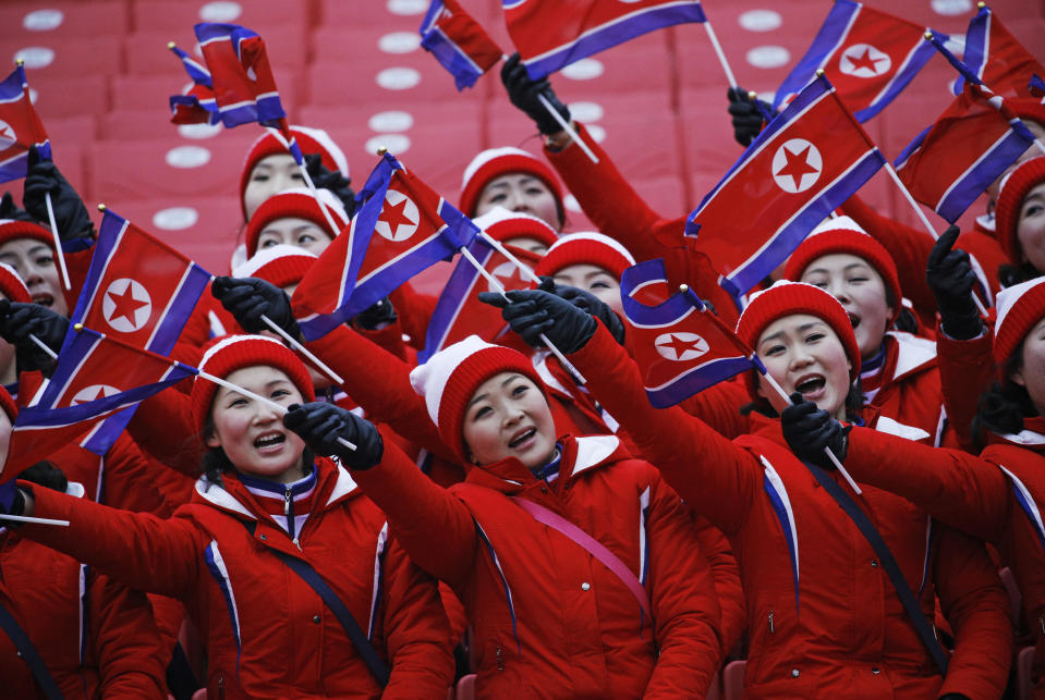 FILE - In this Feb. 14, 2018, file photo, members of the North Korean delegation wave flags at the women's slalom at Yongpyong alpine center at the 2018 Winter Olympics in Pyeongchang, South Korea. At Pyeongchang, North Korea had no real medal contenders, but it was among the most watched nations at the Games, with a huge delegation highlighted by a 229-member strong, all-female cheering squad. (AP Photo/Christophe Ena, File)