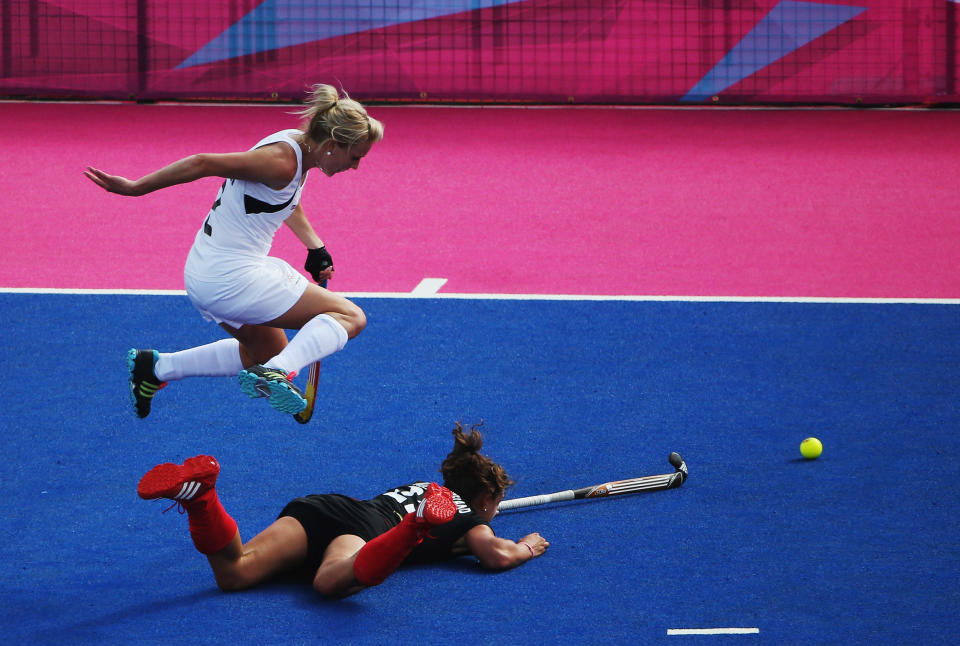 LONDON, ENGLAND - AUGUST 06: Janne Mueller-Wieland of Germany stretches for the ball as Emily Naylor of New Zealand leaps to avoid falling during the Women's Hockey match between Germany and New Zealand on Day 10 of the London 2012 Olympic Games at Riverbank Arena Hockey Centre on August 6, 2012 in London, England. (Photo by Daniel Berehulak/Getty Images)