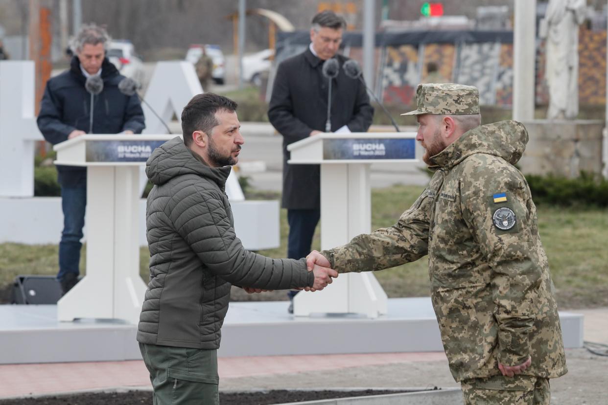 Ukrainian President Volodymyr Zelensky (L)  awards a National Guard serviceman following a ceremony to raise the State Flag of Ukraine near the city of Bucha, outskirts of Kyiv (EPA)