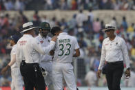 Umpire Marais Erasmus, left, talks to Bangladesh's Nayeem Hasan after he was injured by a delivery from India's Mohammed Shami during the first day of the second test match between India and Bangladesh, in Kolkata, India, Friday, Nov. 22, 2019. (AP Photo/Bikas Das)