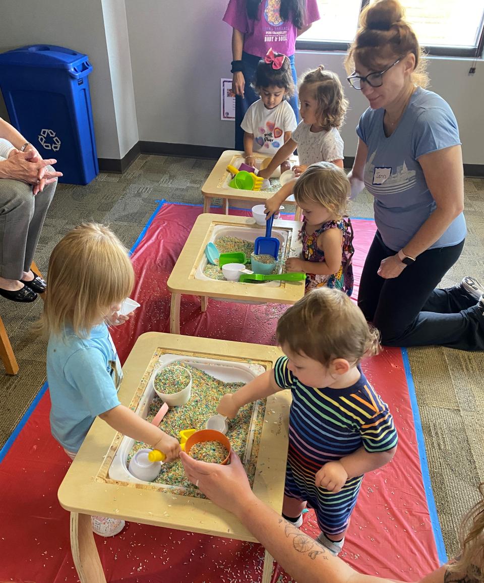Toddlers play at sensory tables, where they practice fine motor and sorting skills at the Bee Cave Public Library.