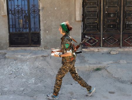 Sheen Ibrahim, Kurdish fighter from the People's Protection Units (YPG) walks in Raqqa, Syria June 16, 2017. REUTERS/Goran Tomasevic