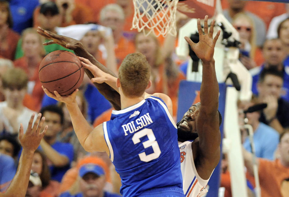 Florida center Patric Young (4) blocks a shot by Kentucky guard Jarrod Polson (3) during the first half of an NCAA college basketball game Saturday, March 8, 2014, in Gainesville, Fla. (AP Photo/Phil Sandlin)
