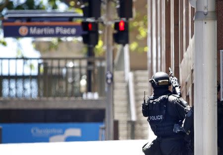 A New South Wales state police officer is seen at a corner near Lindt cafe in Martin Place, where hostages are being held, in central Sydney December 15, 2014. REUTERS/Jason Reed