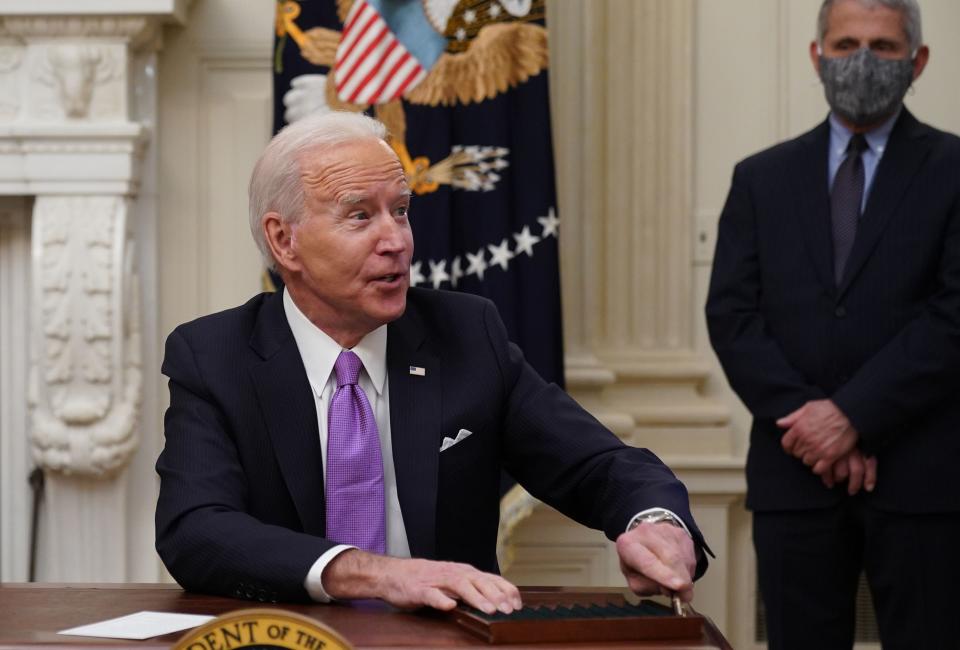 President Joe Biden speaks to the press after signing executive orders as part of the Covid-19 response as Director of NIAID Anthony Fauci looks on.