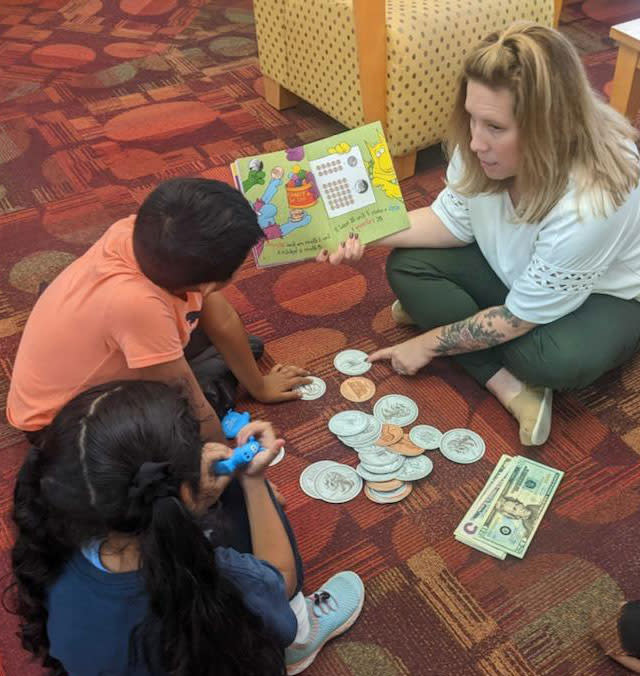 Tori Filas of Virginia Credit Union reads to children at an event at the Richmond Public Library branch.