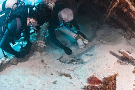 Dr. Philippe Max Rouja, Custodian of Historic Shipwrecks for the government of Bermuda (R) and Dr. James Delgado, director of the Maritime Heritage Program for the U.S. National Oceanic and Atmospheric Administration, excavate the bow of the Civil War blockade runner ship Mary-Celestia, which sank off Bermuda in 1864, in this handout photo provided by LookBermuda/Tane Casserley and taken on June 19, 2011. REUTERS/LookBermuda/Tane Casserley/Handout via Reuters