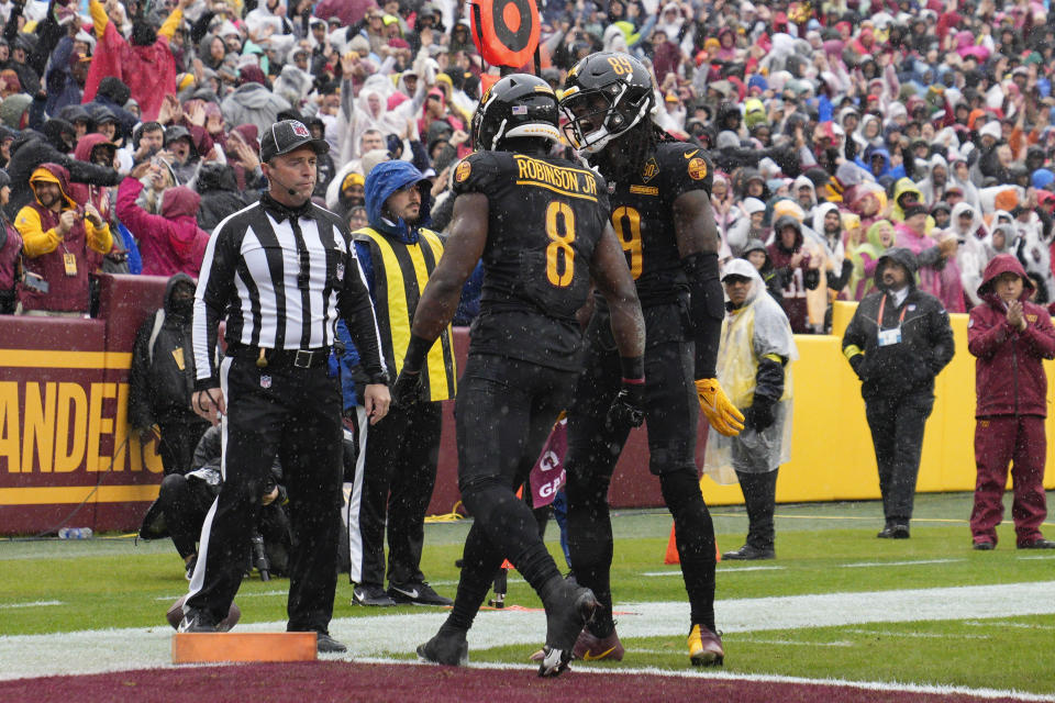 Washington Commanders running back Brian Robinson Jr. (8) celebrates his touchdown with teammate wide receiver Cam Sims (89) during the first half of an NFL football game against the Atlanta Falcons, Sunday, Nov. 27, 2022, in Landover, Md. (AP Photo/Jessica Rapfogel)