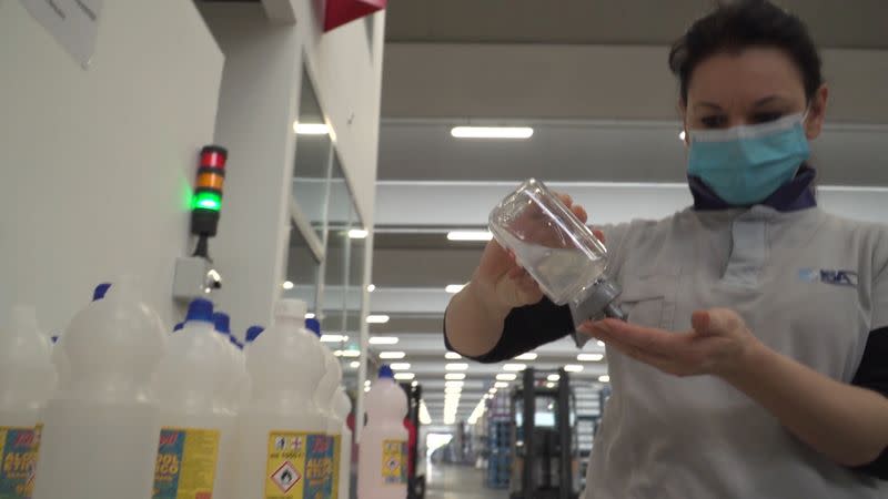 A worker uses hand sanitiser inside a factory in Bastia Umbra