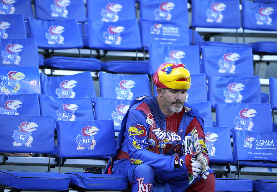 A Kansas fan sits in the stands toward the end of an NCAA college football game against Texas Tech, Saturday, Oct. 16, 2021, in Lawrence, Kan. (AP Photo/Ed Zurga)