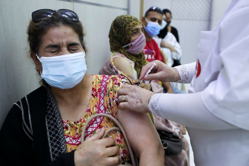 A woman receives the COVID-19 vaccine at a vaccination center in Tunis