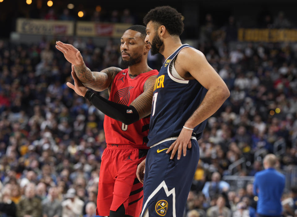 Portland Trail Blazers guard Damian Lillard, back, explains a foul called on Denver Nuggets guard Jamal Murray in the first half of an NBA basketball game Tuesday, Jan. 17, 2023, in Denver. (AP Photo/David Zalubowski)