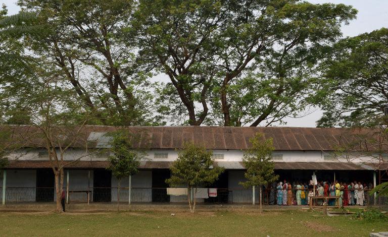 Indian voters queue at a polling station in Dibrugarh on April 7, 2014, as they prepare to vote during national elections