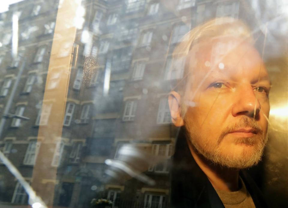 FILE - In this Wednesday May 1, 2019 file photo buildings are reflected in the window as WikiLeaks founder Julian Assange is taken from court, where he appeared on charges of jumping British bail seven years ago, in London. A lawyer for Julian Assange said Friday, Sept. 25, 2020 that the WikiLeaks founder’s situation will be worse if President Donald Trump is re-elected in November than if Democrat rival Joe Biden wins. Edward Fitzgerald said at Assange’s extradition hearing in London that Assange will suffer if he is sent to the U.S. to face spying charges regardless of who wins the Nov. 3 election. (AP Photo/Matt Dunham, File)