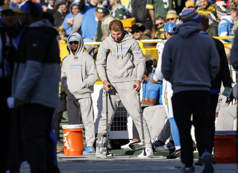 Joey Bosa hangs his head as he observes Chargers-Packers action from the sideline on crutches.
