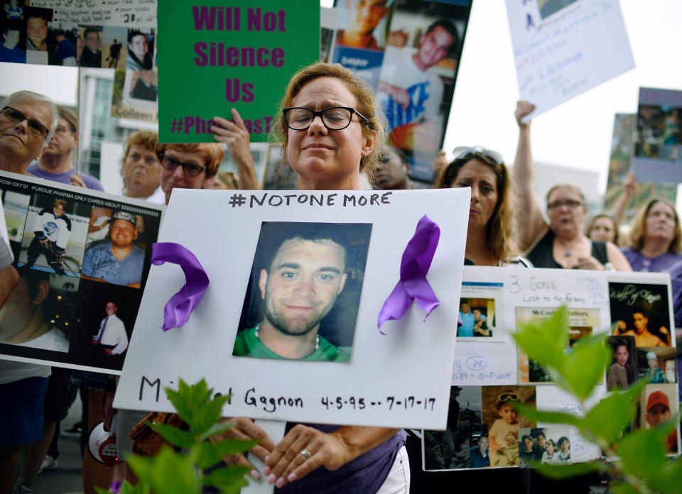 FILE - In this Friday, Aug. 17, 2018, file photo, Christine Gagnon of Southington, Conn., protests with other family and friends who have lost loved ones to OxyContin and opioid overdoses at Purdue Pharma LLP headquarters in Stamford, Conn. Gagnon lost her son Michael 13 months earlier. OxyContin maker Purdue Pharma is expected to file for bankruptcy after settlement talks over the nation’s deadly overdose crisis hit an impasse, attorneys general involved in the talks said Saturday, Sept. 7, 2019, in a message to their counterparts across the country. (AP Photo/Jessica Hill, File)