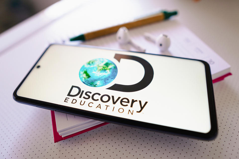 MATO GROSSO DO SUL, BRAZIL - 2022/06/30: In this photo illustration the Discovery Education logo seen displayed on a smartphone next to a book, pen and headphones. (Photo Illustration by Rafael Henrique/SOPA Images/LightRocket via Getty Images)